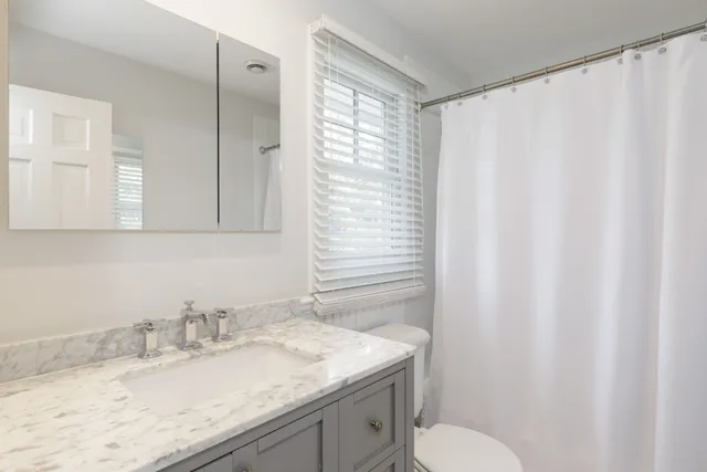 a bathroom with a granite countertop sink and a mirror
