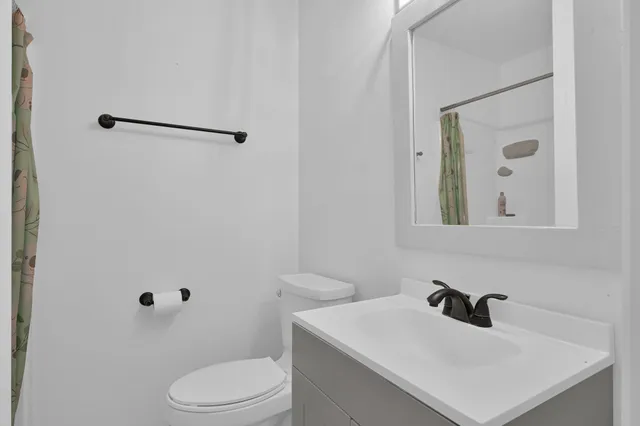 a bathroom with a sink vanity mirror and toilet