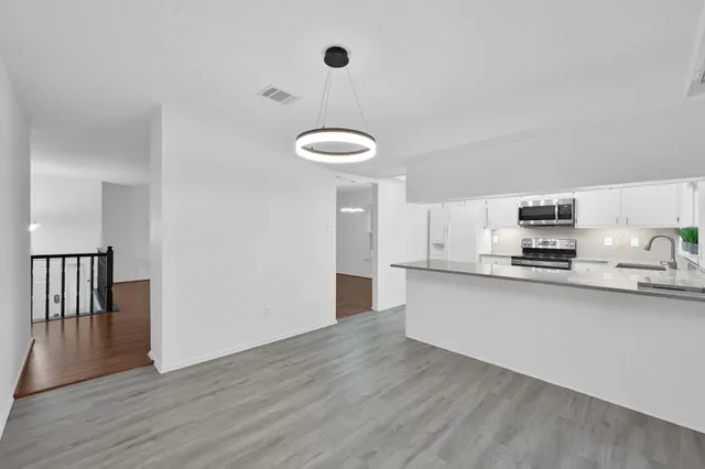 a kitchen with stainless steel appliances granite countertop a stove a sink and a refrigerator