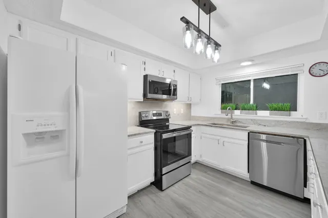 a kitchen with stainless steel appliances granite countertop a stove and a refrigerator