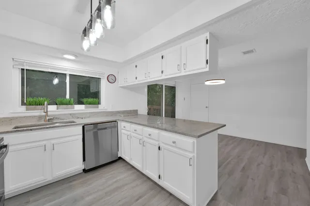 a kitchen with granite countertop white cabinets and white appliances