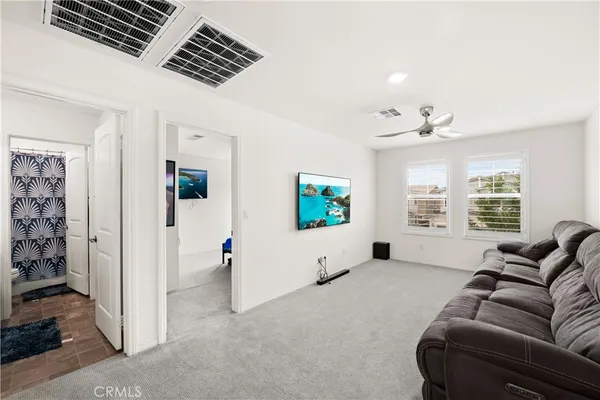 a living room with furniture a flat screen tv and a large window