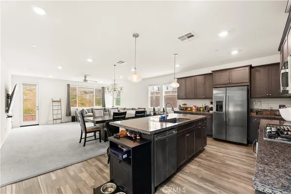 a kitchen with granite countertop a sink counter top space appliances and cabinets