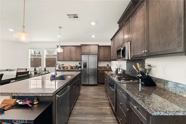 a kitchen with stainless steel appliances granite countertop a sink stove and refrigerator