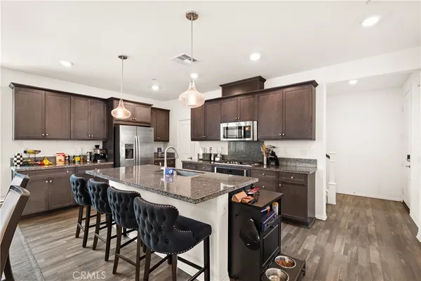 a kitchen with kitchen island a stove a table and chairs in it