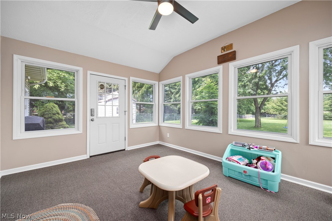 3270 North Ridge Road Vermilion, OH 44089 - Photo 24 of 49 Vaulted ceiling with a ceiling fan, multiple windows, white paneled door with glass inserts, and neutral wall paint