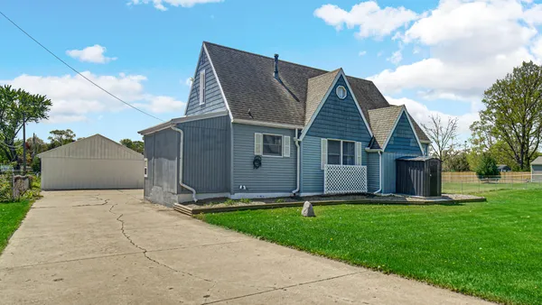 a front view of house with a garden and yard
