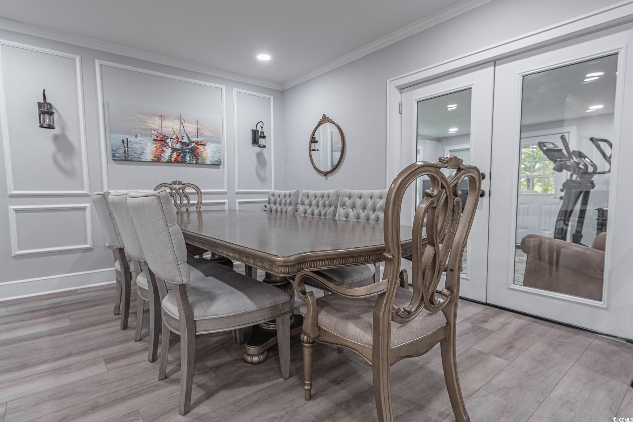 5307 North Ocean Boulevard Myrtle Beach, SC 29577 - Photo 11 of 39 Dining space with a decorative wall, light wood finished floors, crown molding, french doors, and recessed lighting