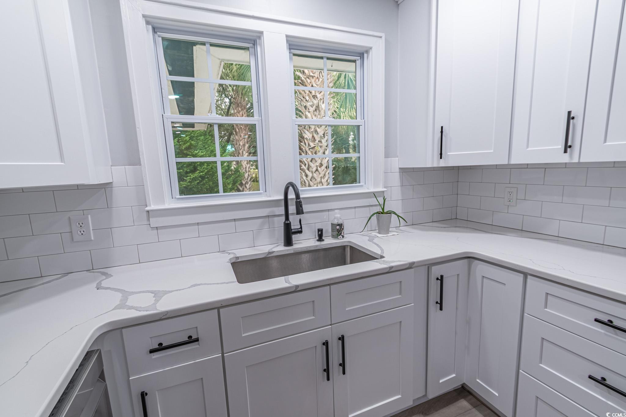 5307 North Ocean Boulevard Myrtle Beach, SC 29577 - Photo 15 of 39 Kitchen featuring decorative backsplash, white cabinetry, and light stone countertops