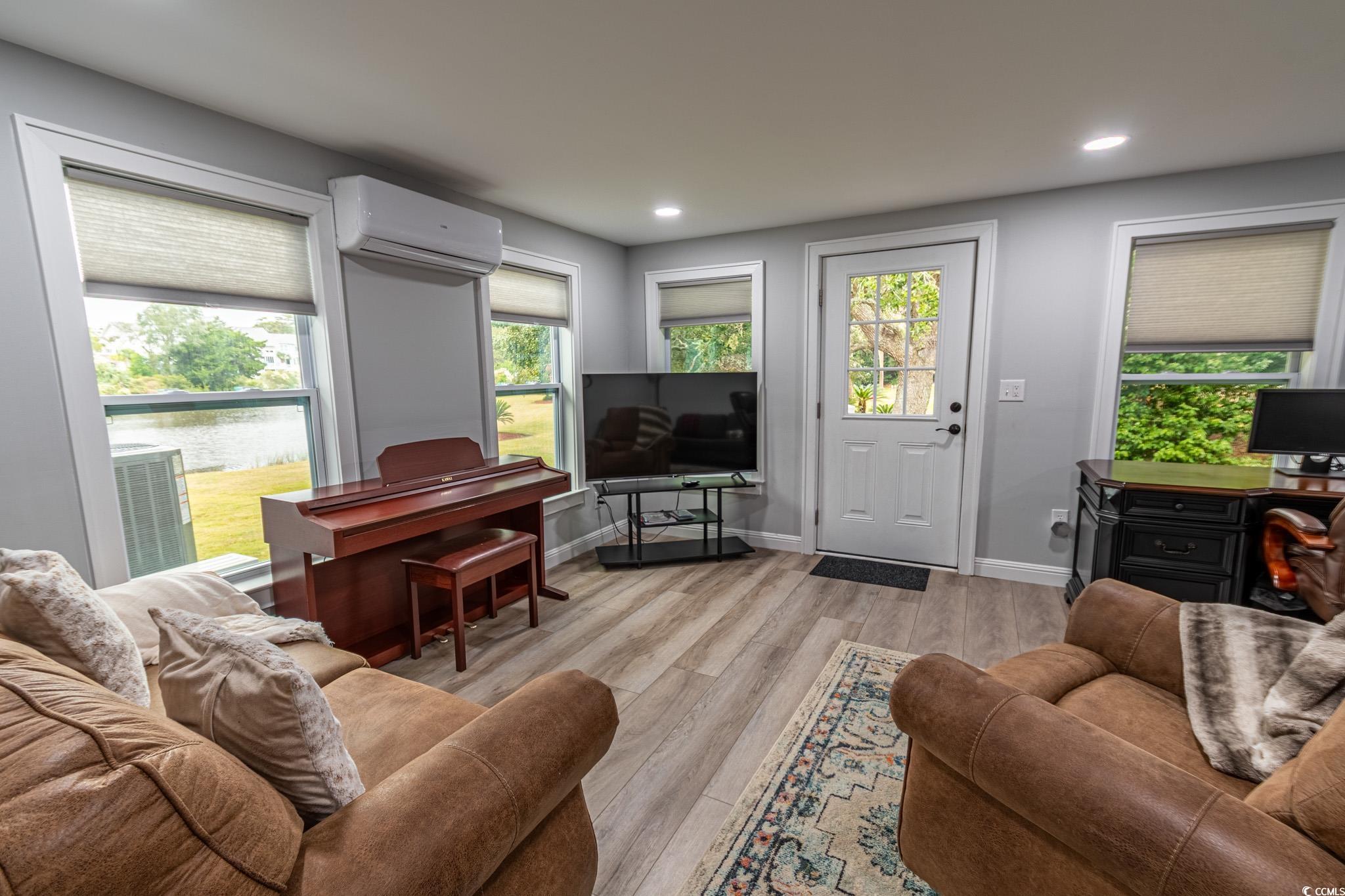 5307 North Ocean Boulevard Myrtle Beach, SC 29577 - Photo 18 of 39 Living area with healthy amount of natural light, light wood-type flooring, a wall unit AC, and recessed lighting
