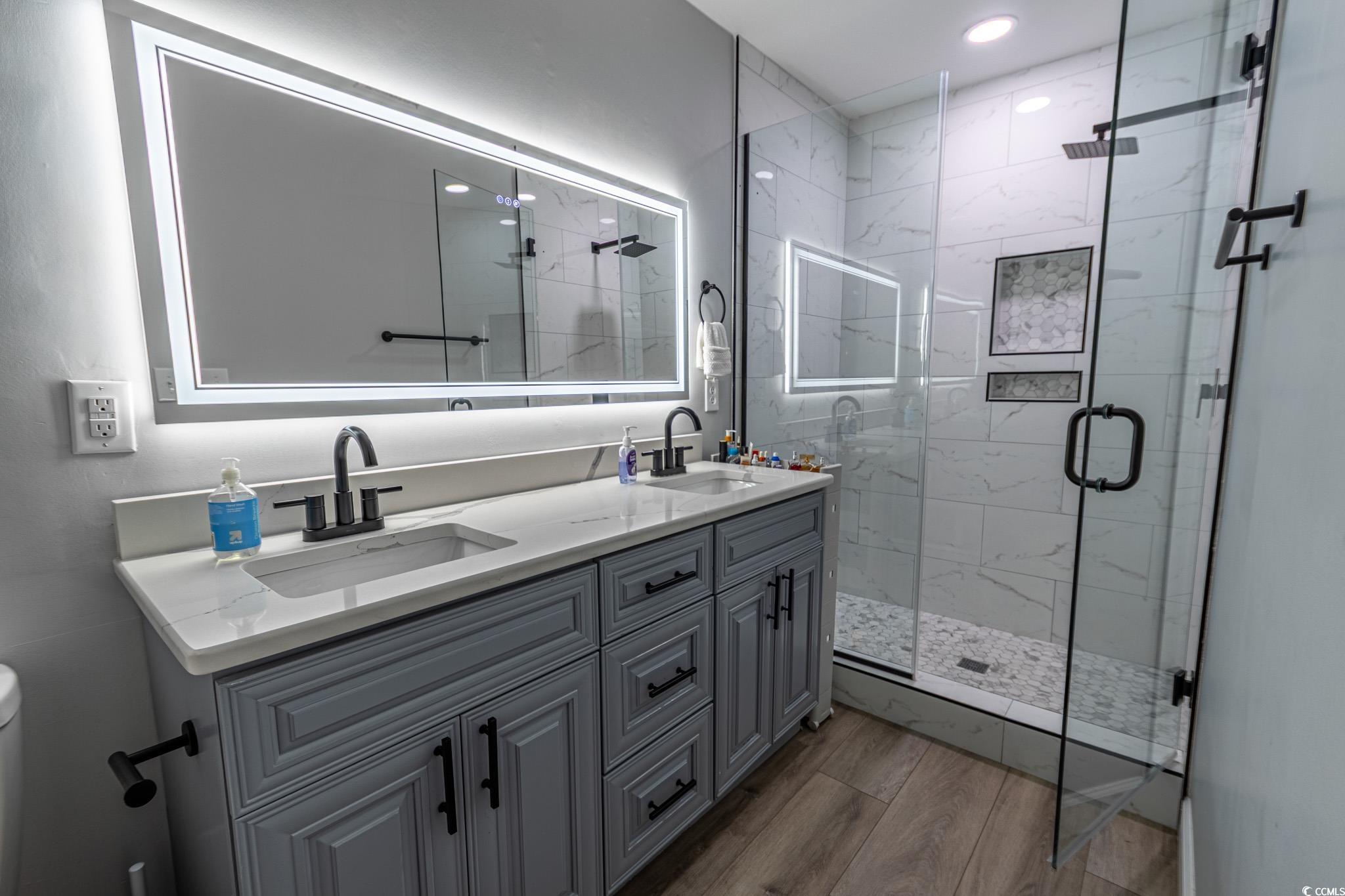 5307 North Ocean Boulevard Myrtle Beach, SC 29577 - Photo 21 of 39 Full bath with double vanity, a marble finish shower, and light wood finished floors