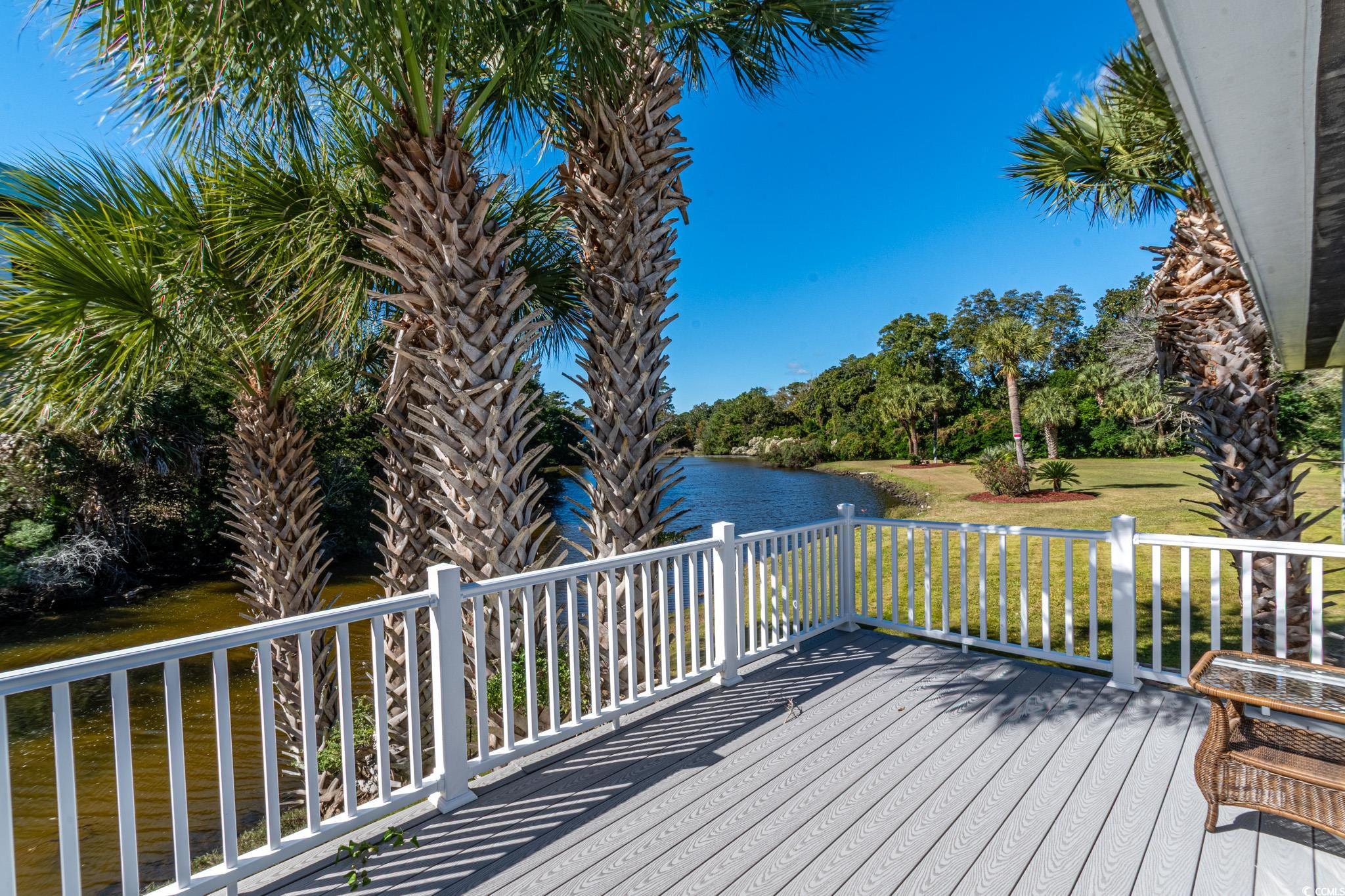 5307 North Ocean Boulevard Myrtle Beach, SC 29577 - Photo 22 of 39 Wooden terrace with a lawn, a water view, and view of scattered trees