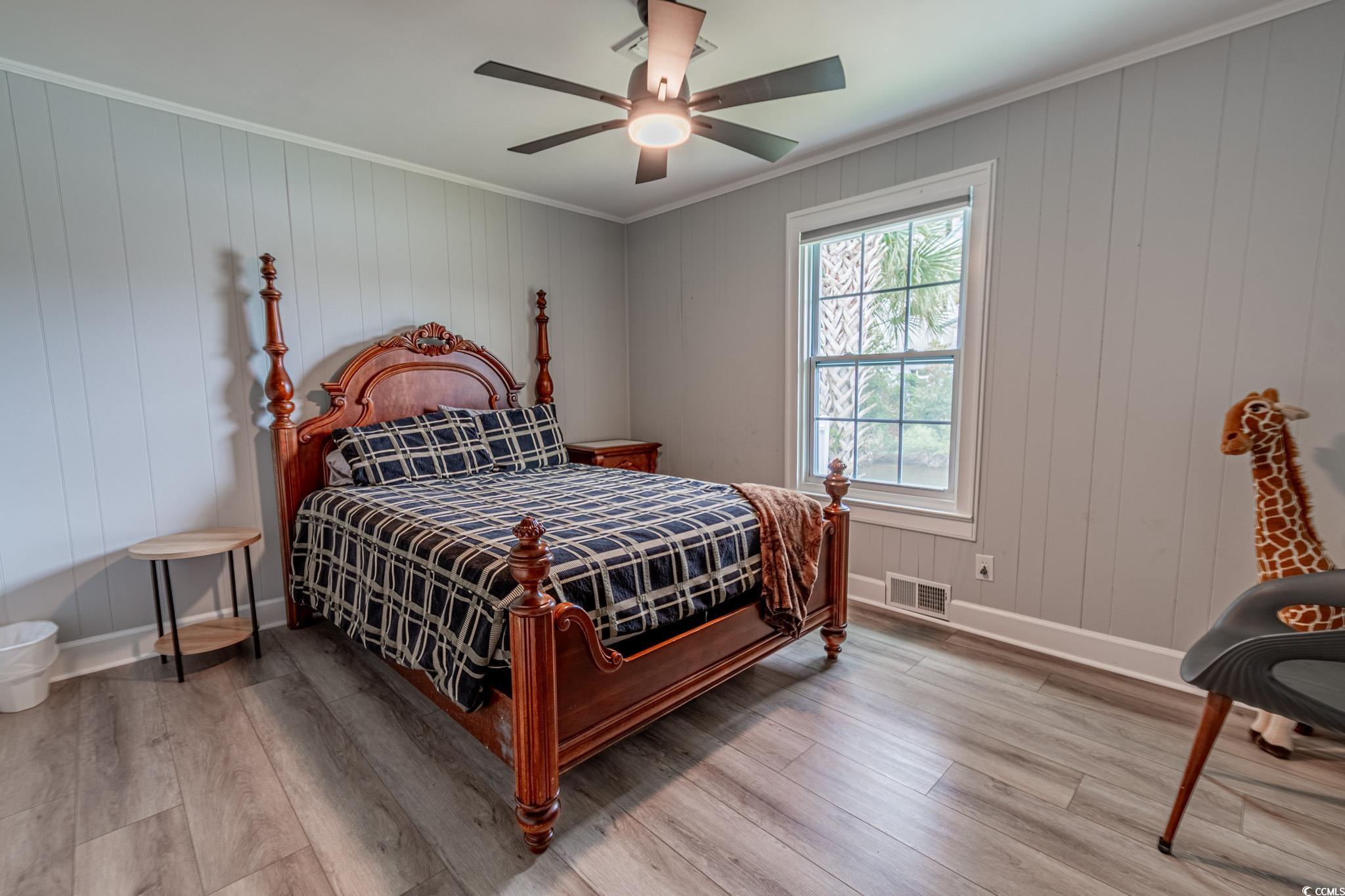 5307 North Ocean Boulevard Myrtle Beach, SC 29577 - Photo 23 of 39 Bedroom featuring wood finished floors, crown molding, ceiling fan, and wooden walls