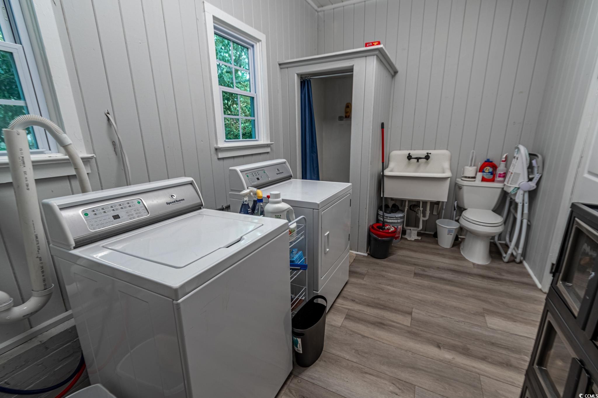 5307 North Ocean Boulevard Myrtle Beach, SC 29577 - Photo 29 of 39 Laundry area featuring wood walls and independent washer and dryer