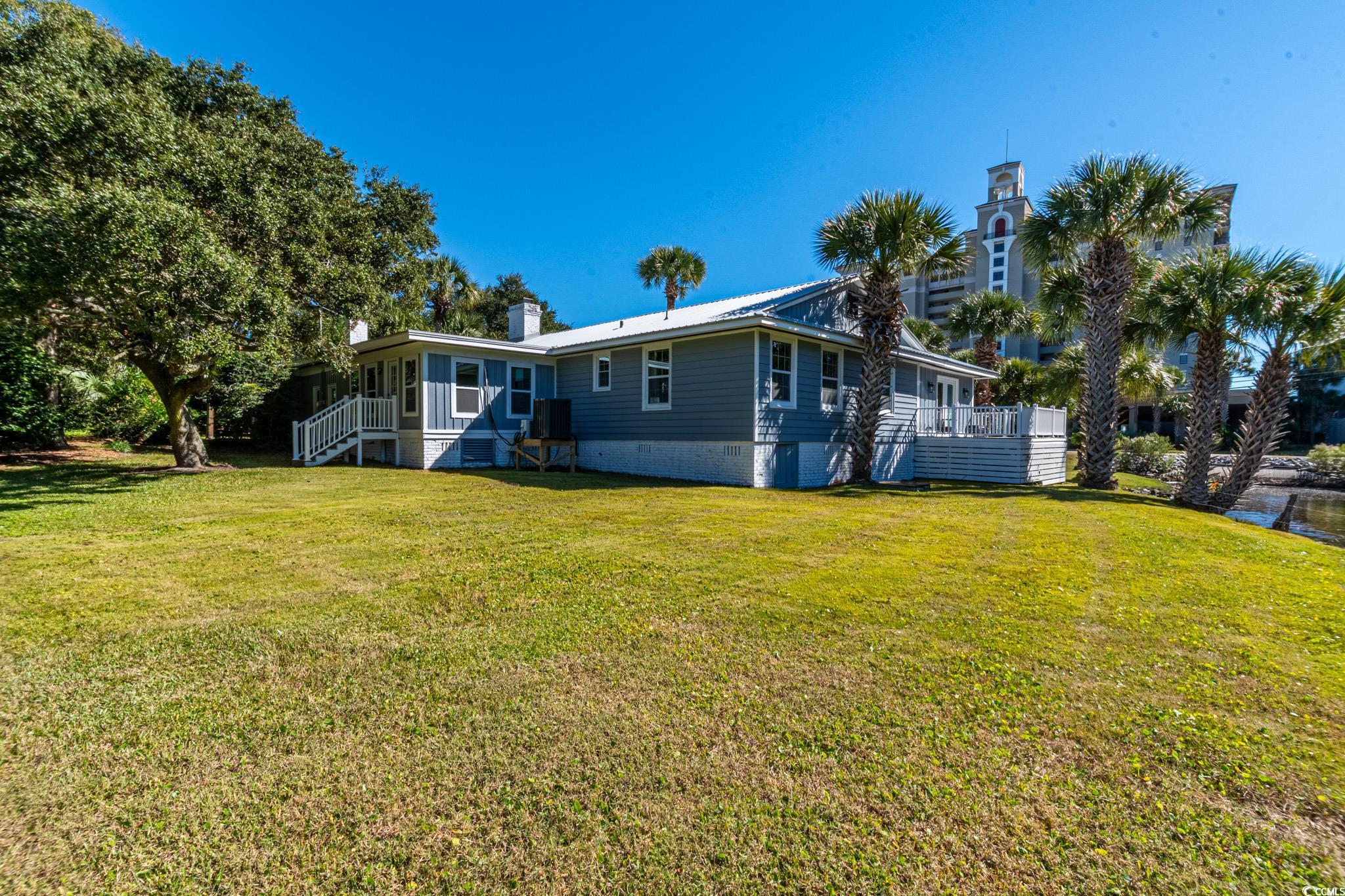 5307 North Ocean Boulevard Myrtle Beach, SC 29577 - Photo 33 of 39 Back of property with a yard, crawl space, a chimney, and a metal roof