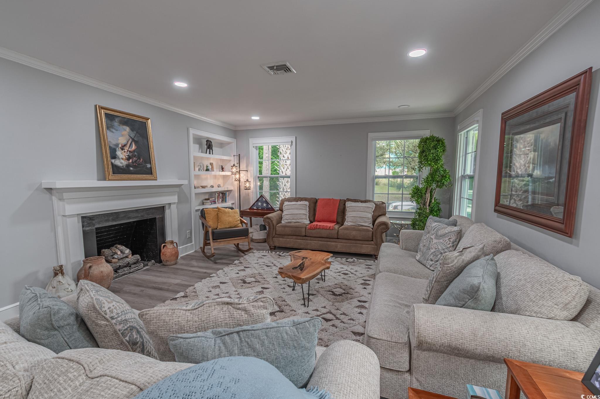 5307 North Ocean Boulevard Myrtle Beach, SC 29577 - Photo 7 of 39 Living area with crown molding, a fireplace, recessed lighting, wood finished floors, and built in shelves