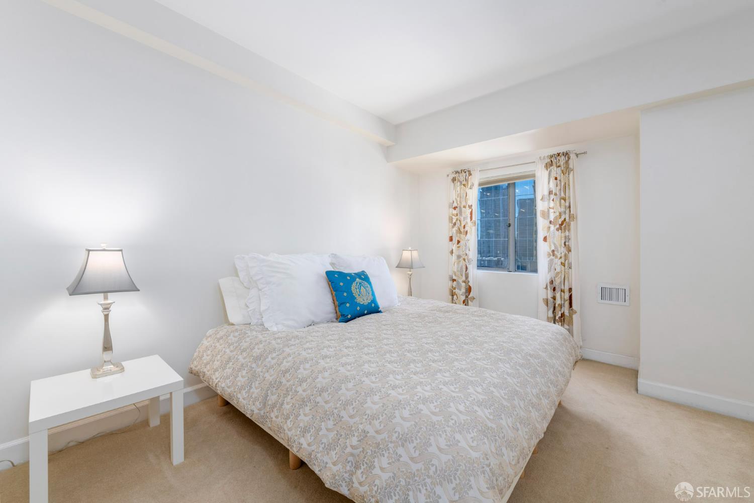 246 2nd Street, Unit 703 San Francisco, CA 94105 - Photo 17 of 30 a bedroom with a bed and a lamp