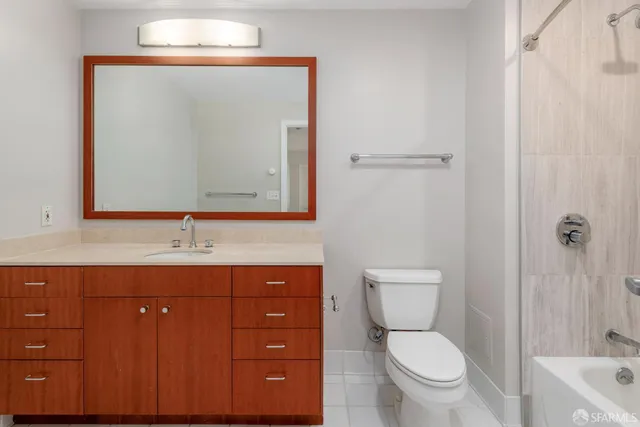 a bathroom with a toilet a sink a vanity and mirror