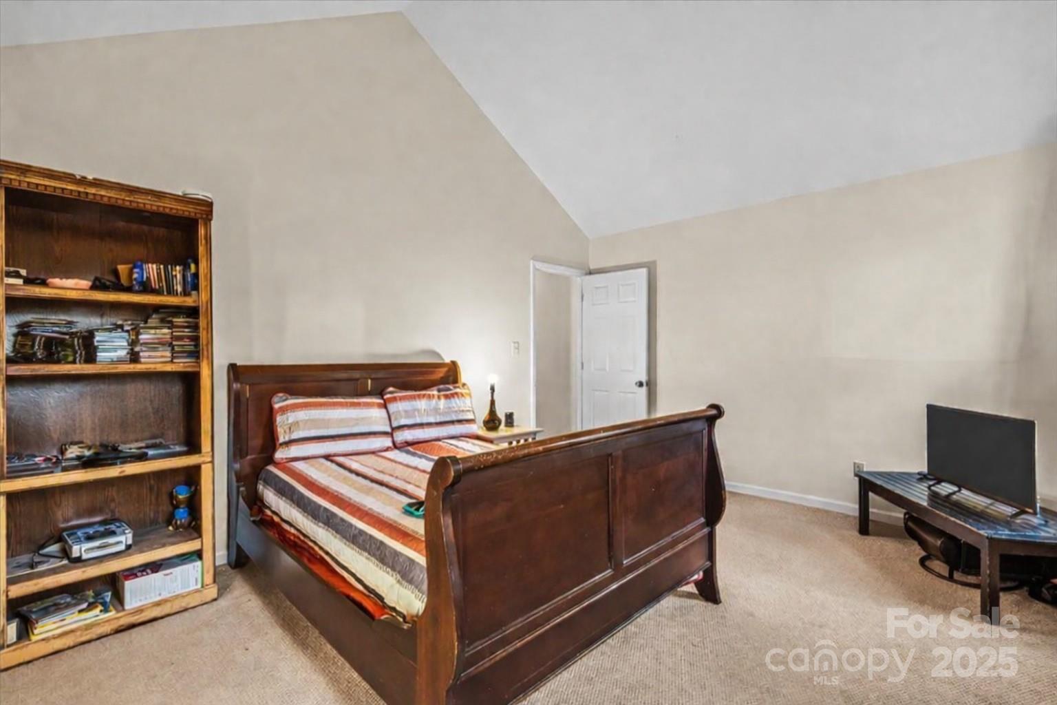 7022 Plott Road Charlotte, NC 28215 - Photo 22 of 27 a bedroom with a bed and a book shelf