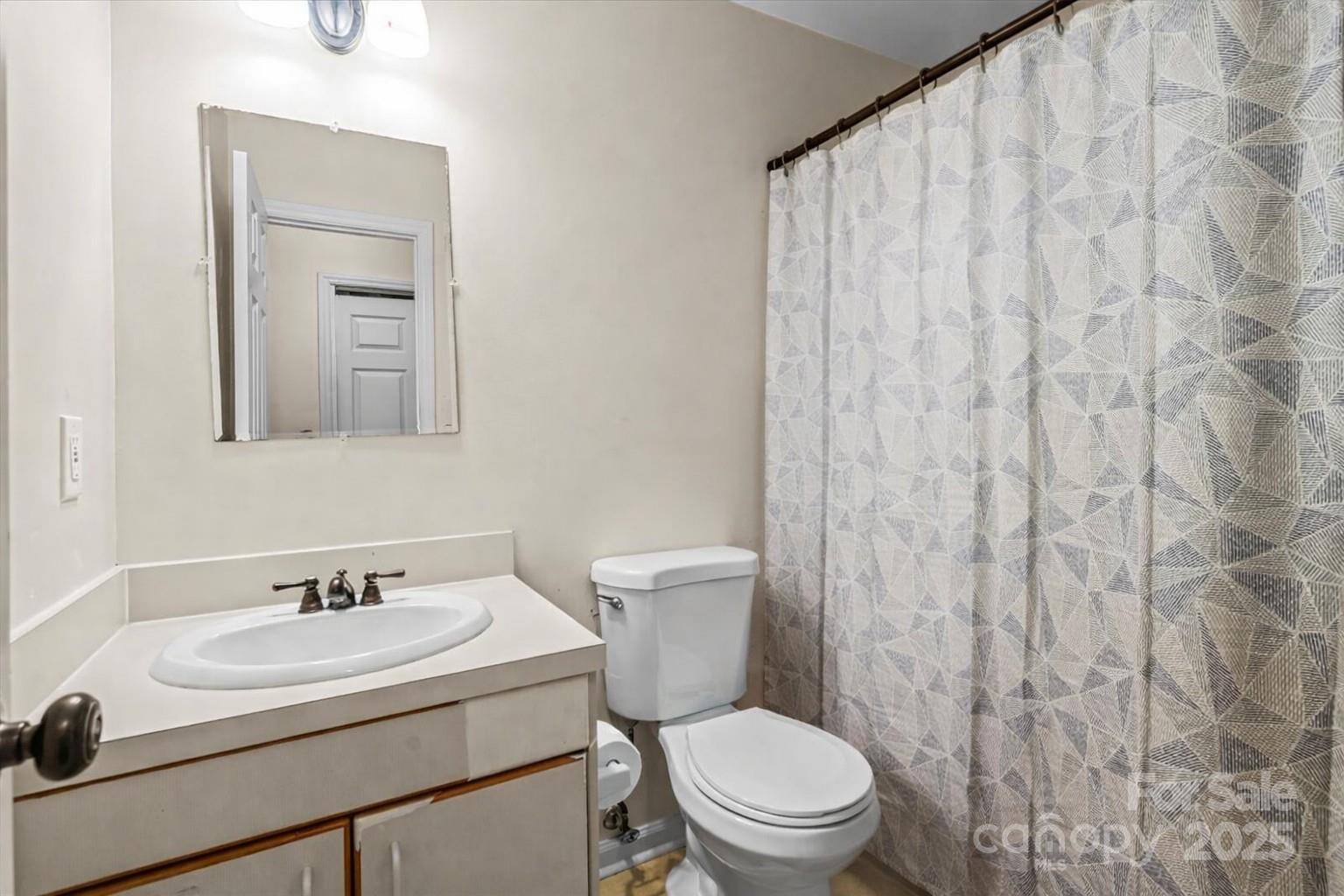 7022 Plott Road Charlotte, NC 28215 - Photo 23 of 27 a bathroom with a sink a toilet and shower curtain