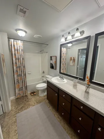 a spacious bathroom with a double vanity sink mirror and toilet