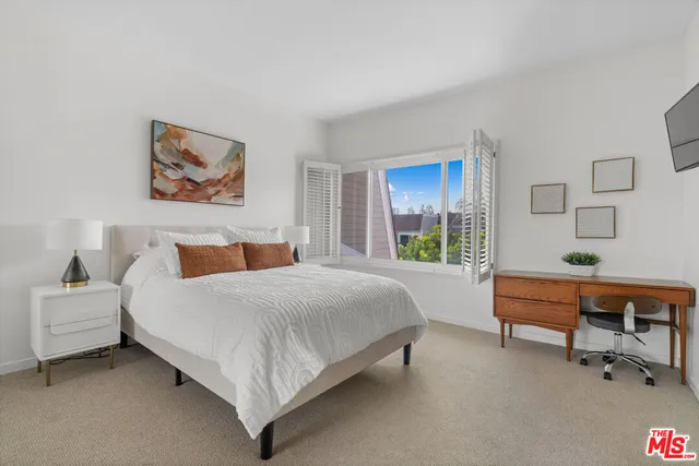 a spacious bedroom with a bed and a window