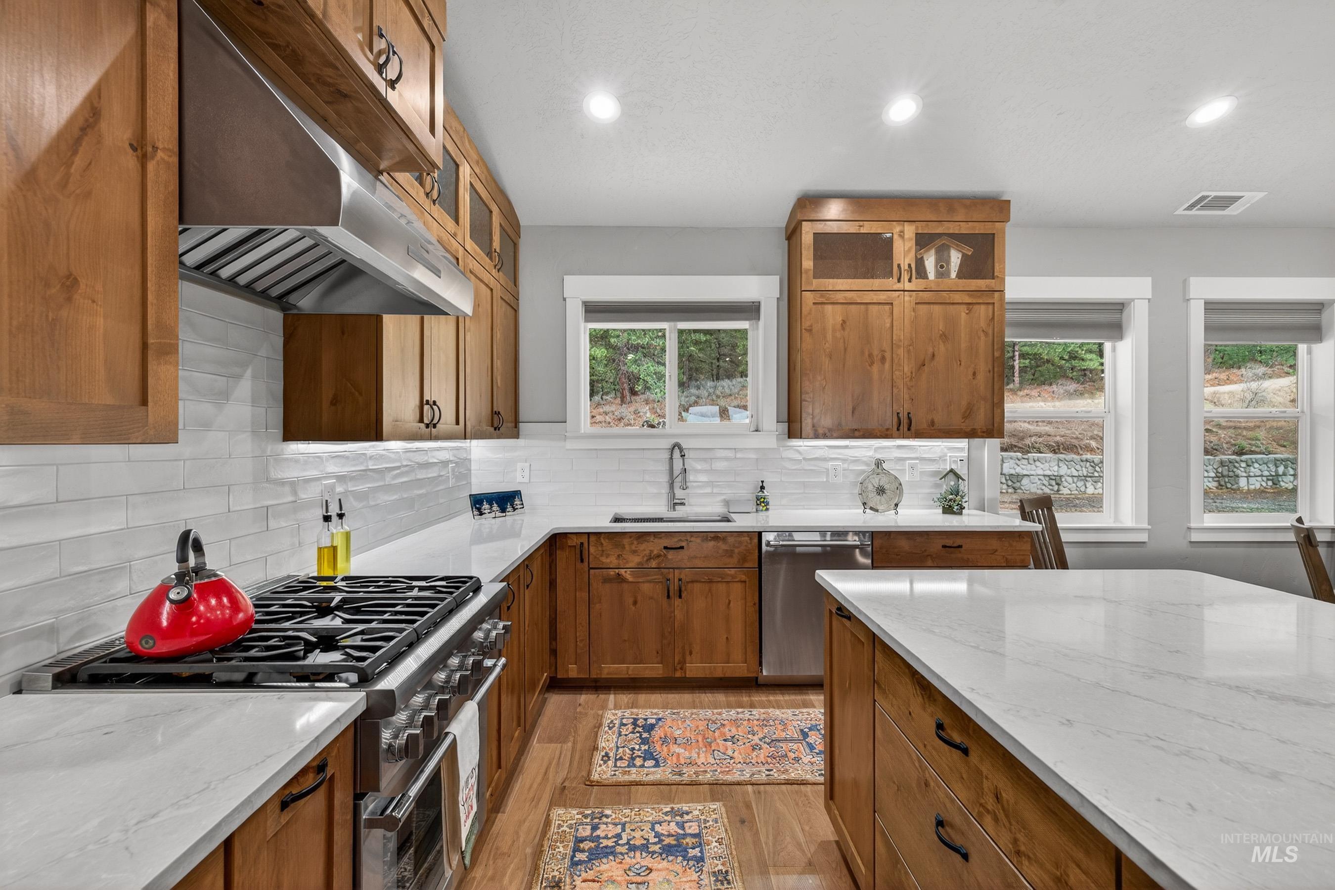 10191 Timberrim Drive Cascade, ID 83611 - Photo 15 of 44 Kitchen with wood finish cabinets, light stone countertops, recessed lighting, and stainless steel appliances