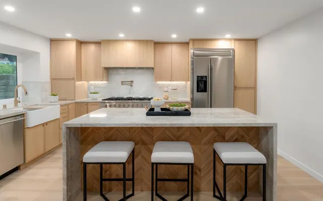 a kitchen with a sink dishwasher stove and white cabinets with wooden floor