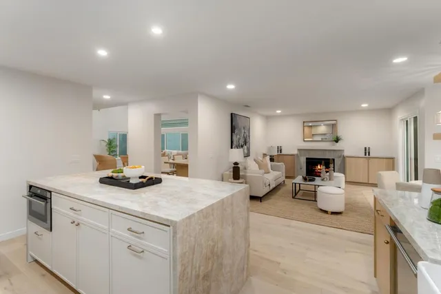 a living room with furniture a fireplace and a large window