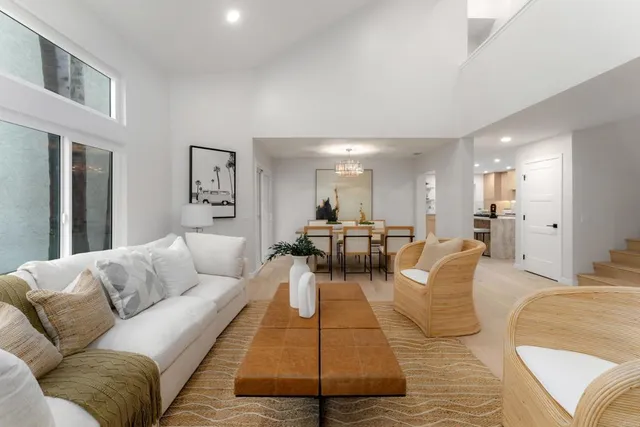 a living room with furniture wooden floor and a large window
