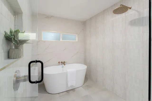a white bath tub sitting next to a shower
