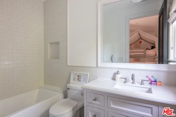 a utility room with stainless steel appliances granite countertop a sink and a window