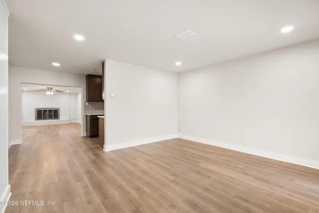 a view of empty room with wooden floor