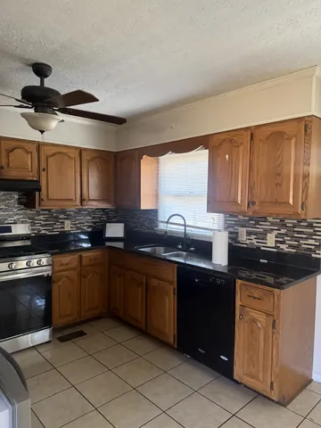 a kitchen with stainless steel appliances kitchen island granite countertop a sink and a stove