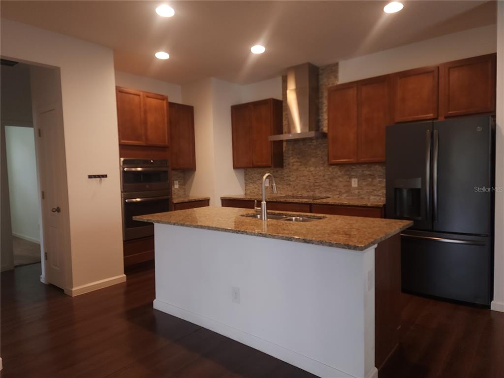 3230 Stratton Circle Kissimmee, FL 34744 - Photo 13 of 28 a kitchen with stainless steel appliances granite countertop a refrigerator a sink and a stove
