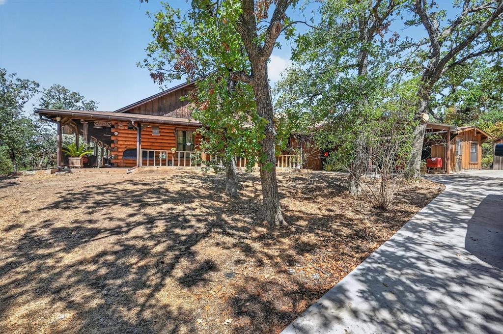 1623 3 Skillet Road Springtown, TX 76082 - Photo 32 of 40 Wood-sided exterior featuring an expansive covered porch with wood columns and railings