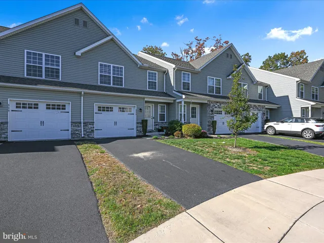 a front view of a house with a garden and yard