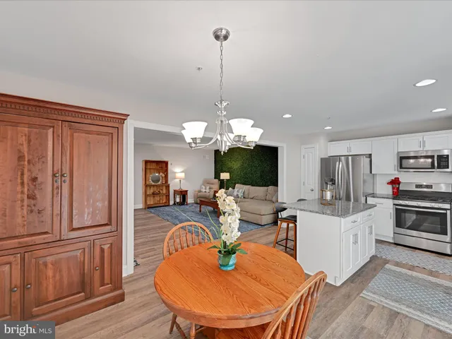 a living room with furniture a flat screen tv and kitchen view