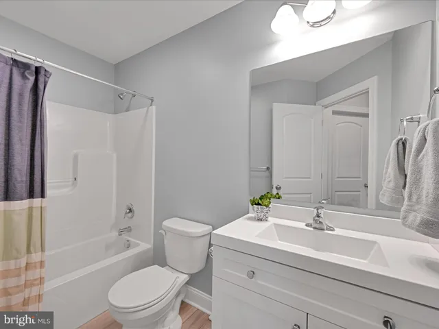 a bathroom with a sink toilet a mirror a bathtub and shower