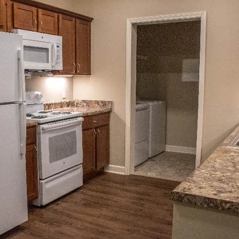 a kitchen with granite countertop a stove and a refrigerator