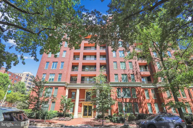 a front view of a multi story building with a yard