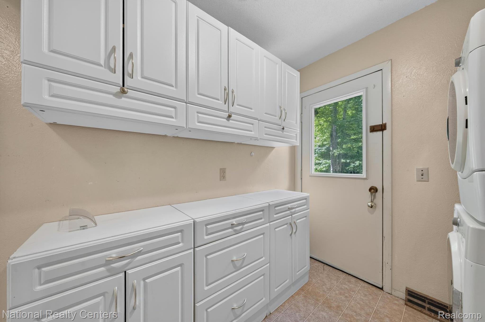 3107 Dean Road Lambertville, MI 48144 - Photo 23 of 45 Laundry room featuring white cabinetry, a light-colored door with a window, and tile flooring