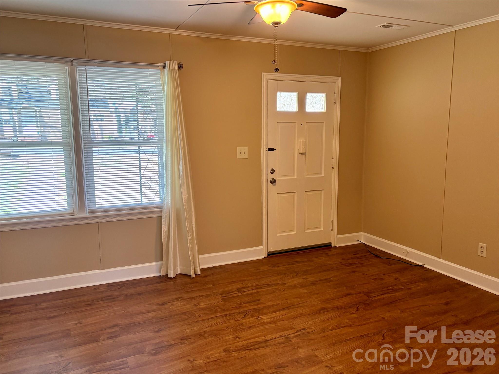324 East Rhodes Street Lincolnton, NC 28092 - Photo 2 of 10 an empty room with wooden floor cabinet and windows