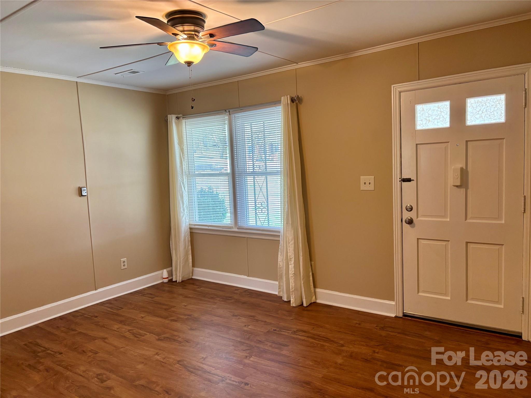 324 East Rhodes Street Lincolnton, NC 28092 - Photo 3 of 10 a view of an empty room with window and wooden floor