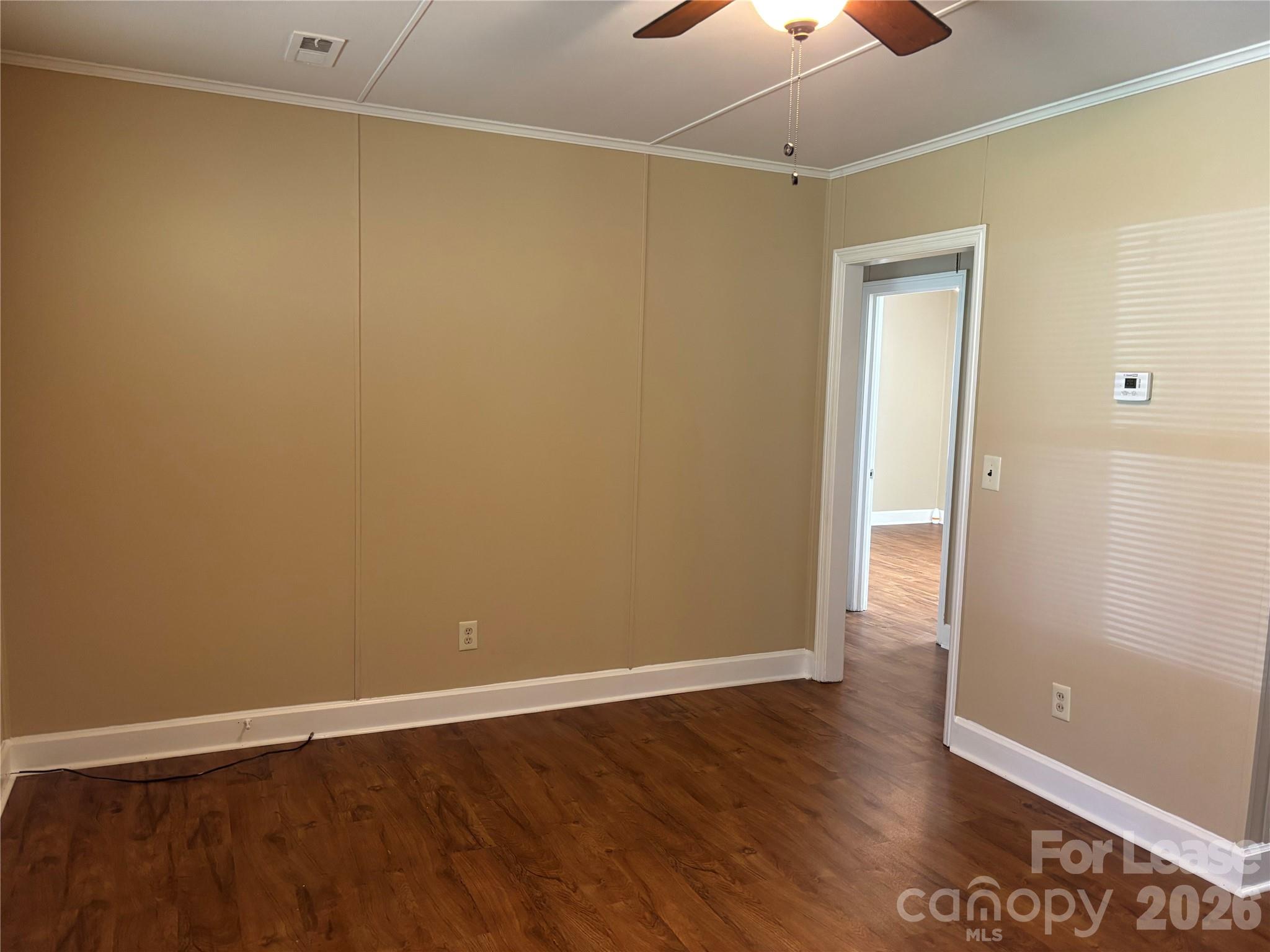 324 East Rhodes Street Lincolnton, NC 28092 - Photo 4 of 10 a view of an empty room with wooden floor and a window