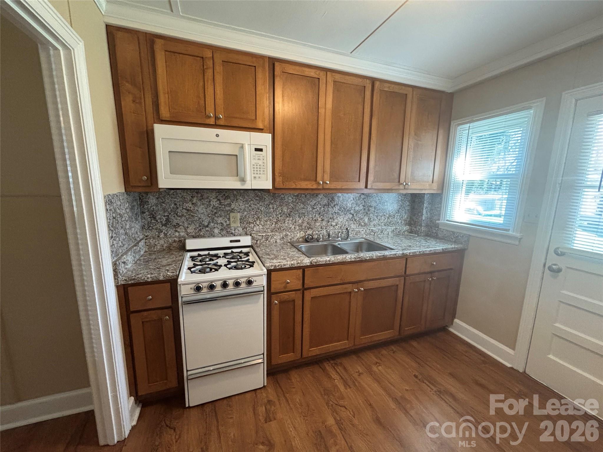 324 East Rhodes Street Lincolnton, NC 28092 - Photo 6 of 10 a kitchen with granite countertop wooden cabinets and white appliances