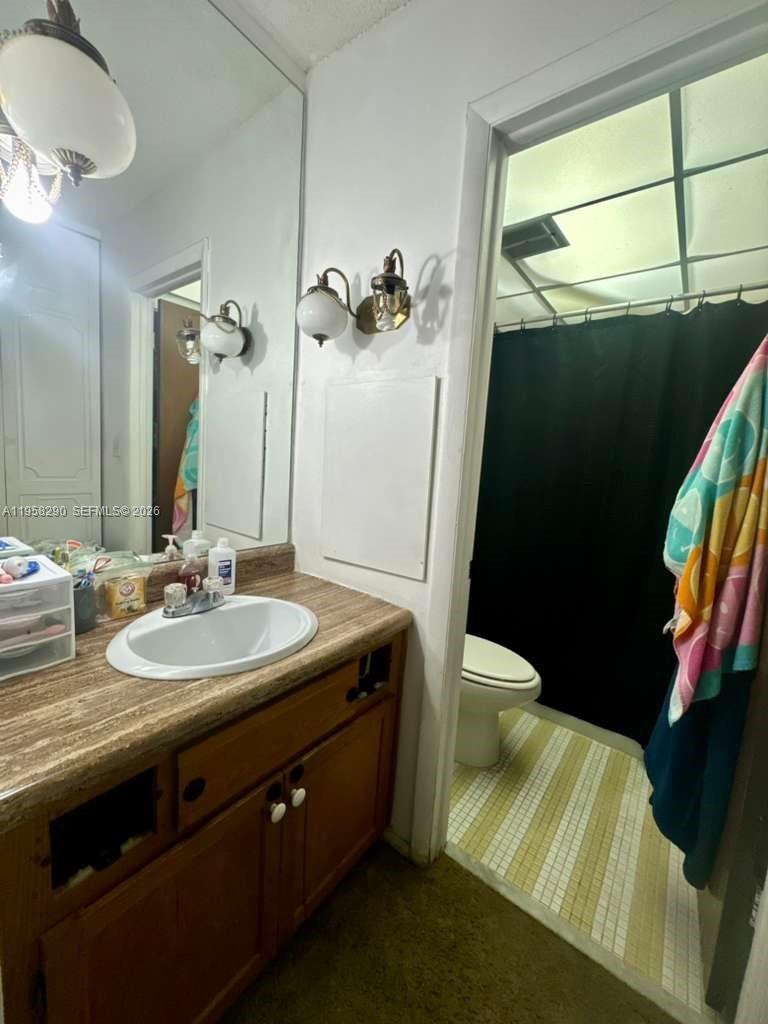 3720 Inverrary Drive, Unit 2S Lauderhill, FL 33319 - Photo 12 of 31 a bathroom with a granite countertop sink a toilet and a mirror