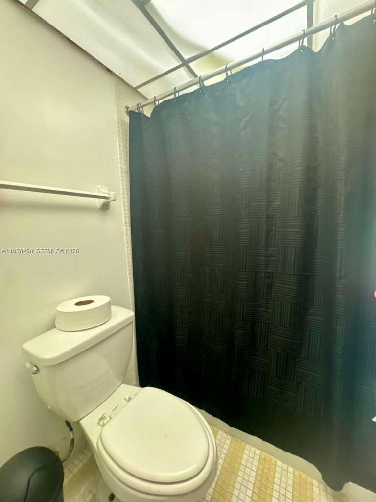 3720 Inverrary Drive, Unit 2S Lauderhill, FL 33319 - Photo 14 of 31 a white toilet sitting next to a shower curtain
