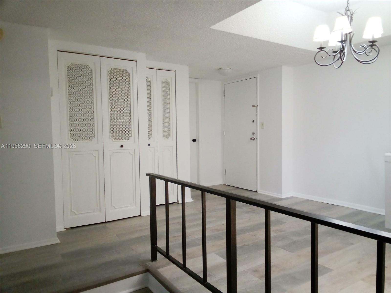 3720 Inverrary Drive, Unit 2S Lauderhill, FL 33319 - Photo 21 of 49 a view of a hallway with wooden floor and chandelier