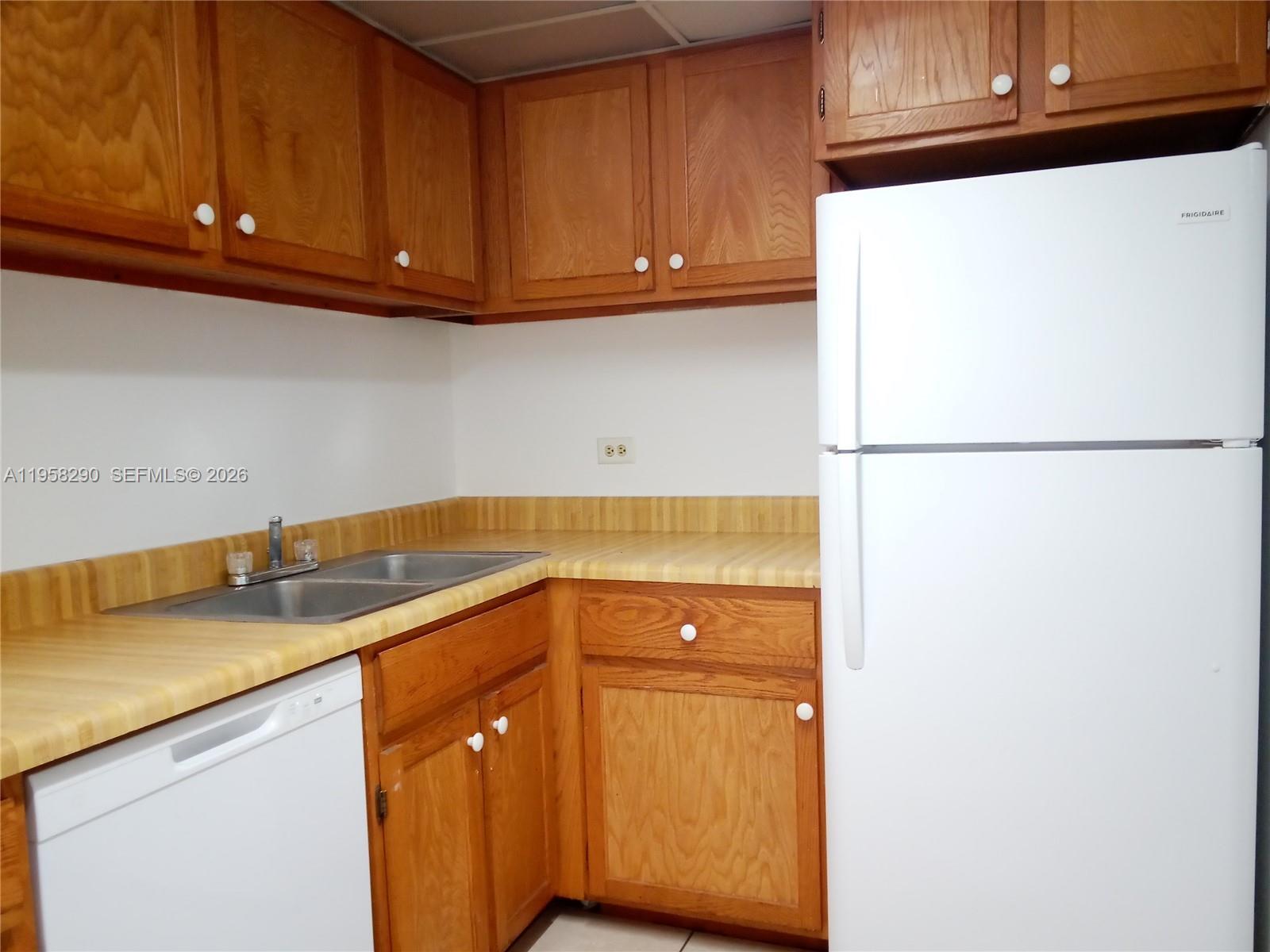 3720 Inverrary Drive, Unit 2S Lauderhill, FL 33319 - Photo 28 of 49 a kitchen with a sink and a refrigerator